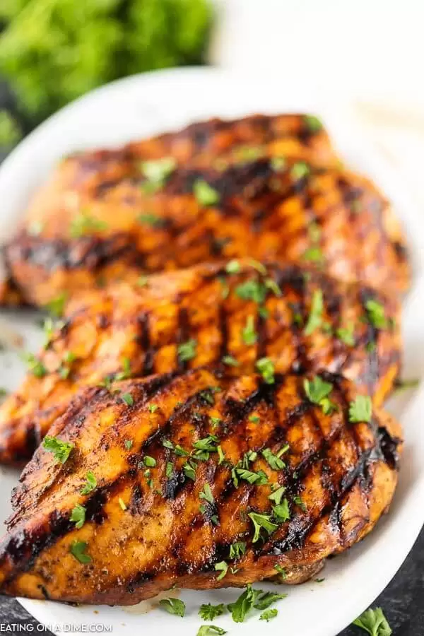 Grilled chicken on white plate with parsley 