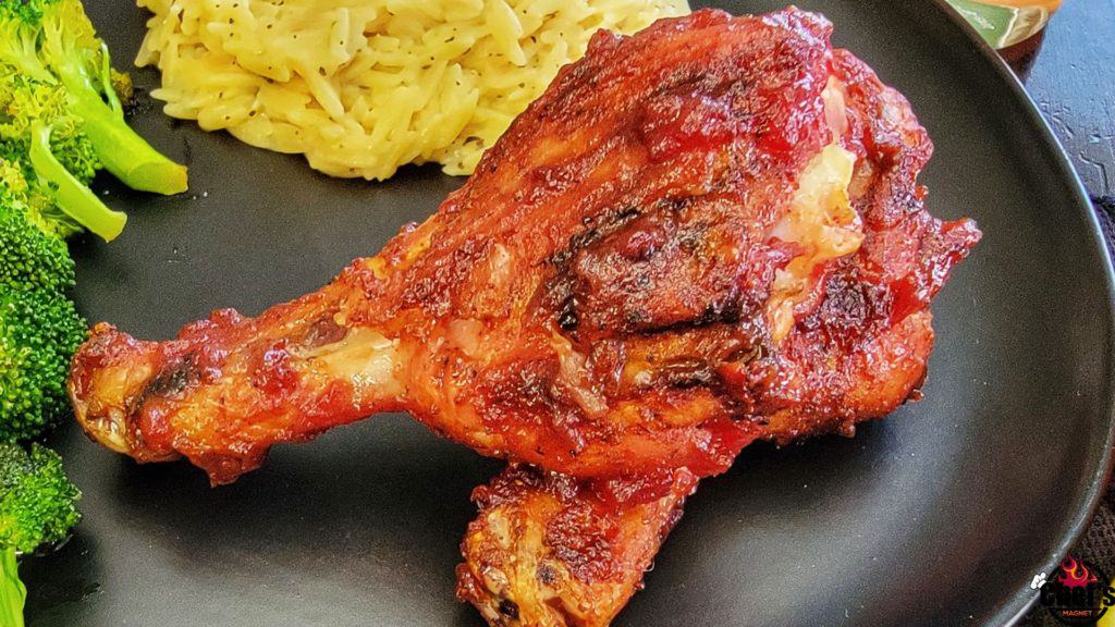 Smoked Cherry Drumsticks with Glaze and sides on black plate