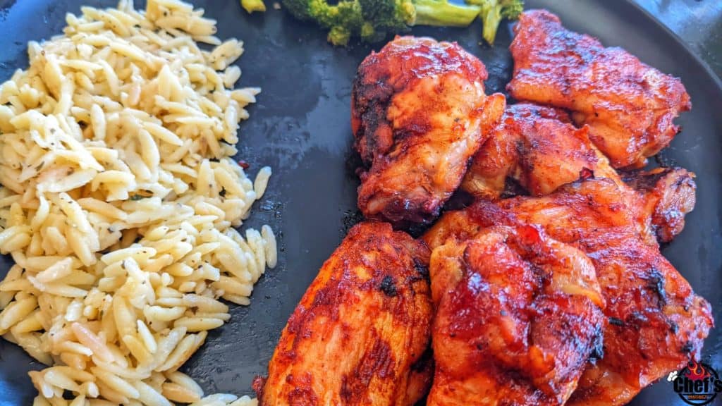 Smoked wings in glaze on black plate with sides