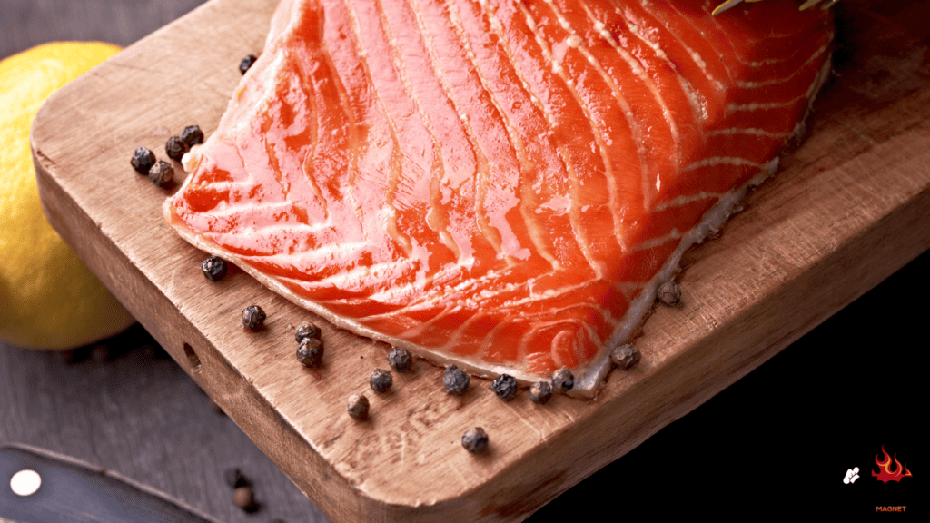 Cooked salmon on wood with lemon and peppercorns 